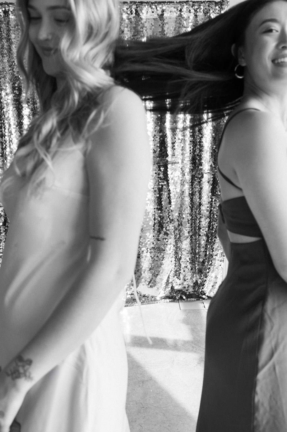 Guests dancing in front of a sequin backdrop